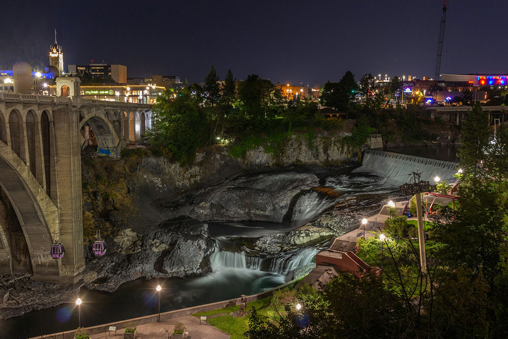 Photo of the night sky, urban bridge, and night city in Spokane, Washington.